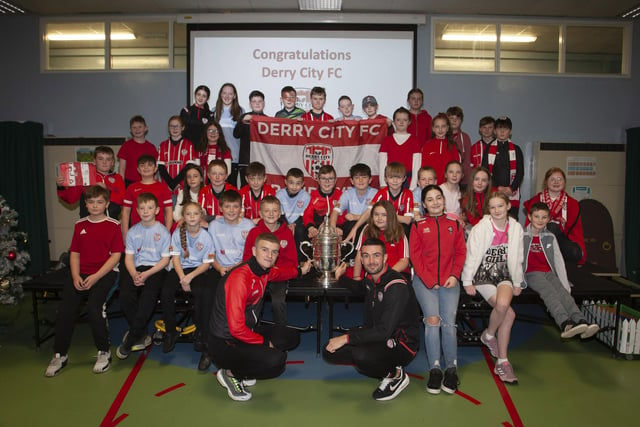 Derry players Caoimhin Porter and Michael Duffy and the FAI Cup pictured with the P7 classes at Greenhaw PS.