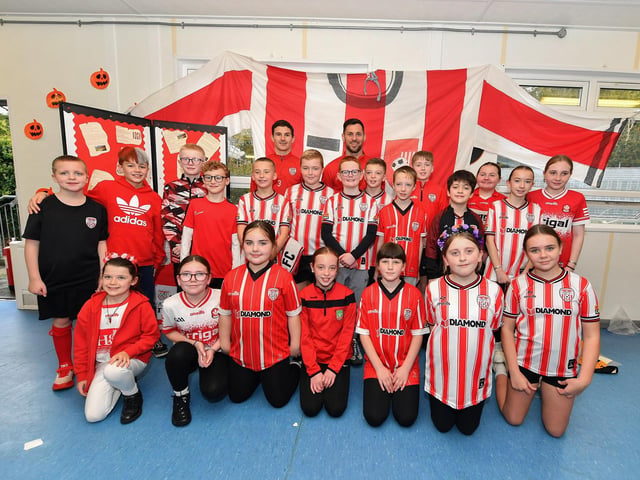 Pupils from Gaelscoil Eadain Mhoir pictured with Derry City’s Ciaran Coll and Pat Hoban during their visit to the school on Monday morning. Photo: George Sweeney