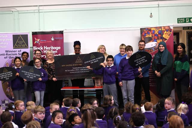 Director of the North West Migrants Forum, Lilian Seenoi Barr, getting a helping hand to launch this year’s Advancing Race Equality Awards from the young people at Mallusk Integrated Primary School. Mallusk won last year’s ‘Anti-Racism School of the Year’ title for its efforts in promoting inclusivity and diversity.
