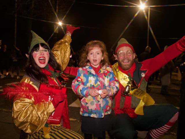 Santa's little helpers with one of the many young children who gathered in the city centre.