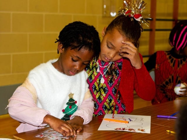 Young people doing Christmas crafts at the African Caribbean Community Network family Christmas party in Derry