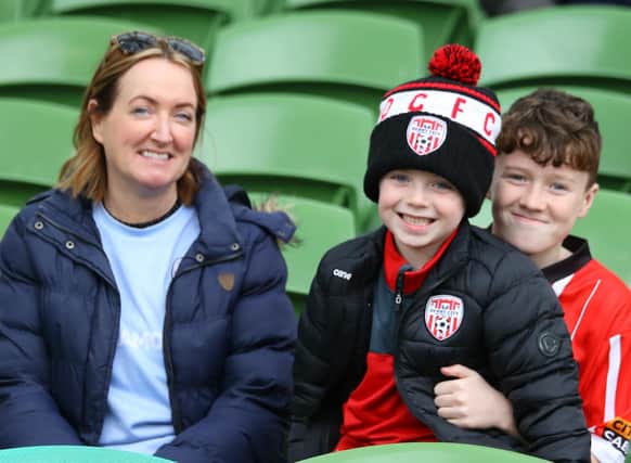 ALL SMILES . . . This young family take their seats ahead of kick-off at the Aviva Stadium.