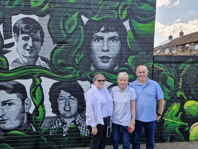 Members of Kevin McElhinney's family underneath his portrait on the new mural at Lisfannon Park.