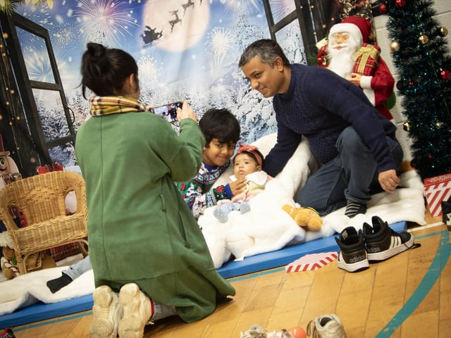 A family uses a beautiful Christmas backdrop to capture their newborn baby during Saturday's 'Christmas Get Together' at Long Tower Youth Club. (Photos: Jim McCafferty Photography) : .