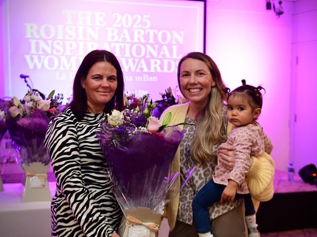 Aoibheann Gillespie–Mules receiving a presentation on behalf of her mother Daisy Mules, from Aine Doherty, daughter of Roisin Barton.