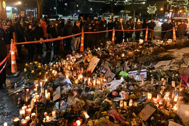 People mourn at a makeshift memorial in the area where Alex Pretti was shot dead. (Photo by Octavio JONES / AFP via Getty Images)