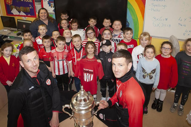 Former pupils Shane and Patrick McEleney take the FAI Cup into Mrs. McLaughlin’s P4 class at Steelstown Primary School. (Photo: Jim McCafferty)