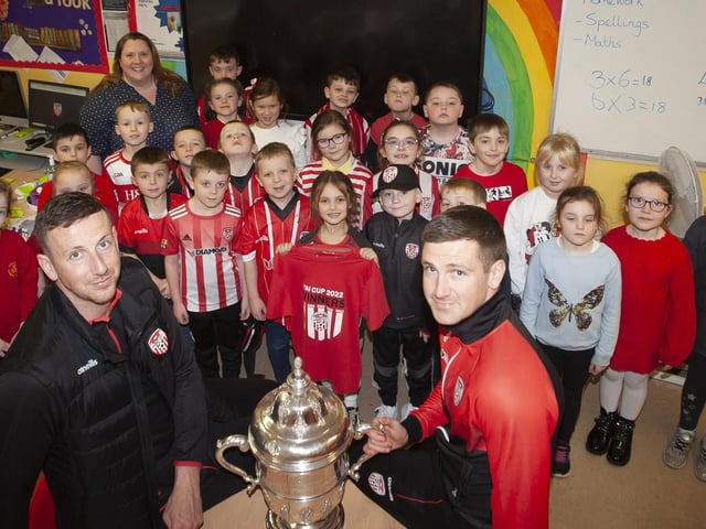 Former pupils Shane and Patrick McEleney take the FAI Cup into Mrs. McLaughlin’s P4 class at Steelstown Primary School. (Photo: Jim McCafferty)