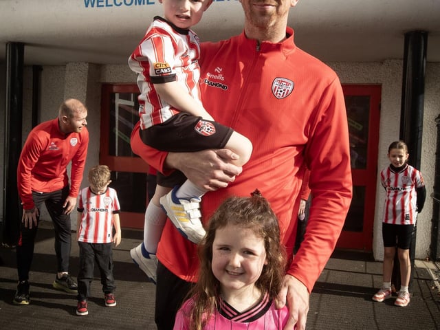 Derry's Shane McEleney with his children and Hollybush PS pupils Calladh and Rossa on Tuesday.