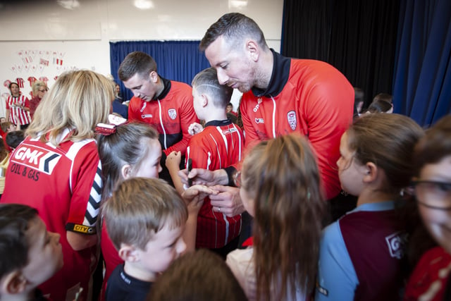 Shane and Patrick McEleney signing autographs during their visit to Steelstown Primary School on Tuesday. (Photo: Jim McCafferty)