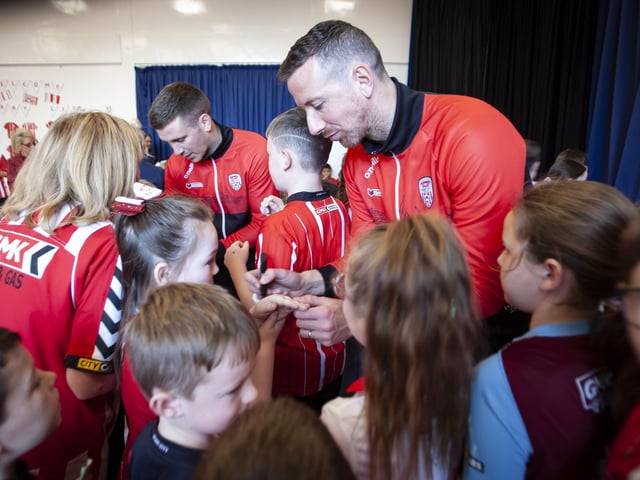 Shane and Patrick McEleney signing autographs during their visit to Steelstown Primary School on Tuesday. (Photo: Jim McCafferty)