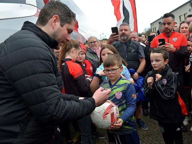 Derry City’s manager Ruaidhrí Higgins signs a football for a fan on Saturday morning prior to the team’s departure for Dublin ahead of tomorrow’s FAI Cup Final against Shelbourne. George Sweeney. DER2244GS – 56