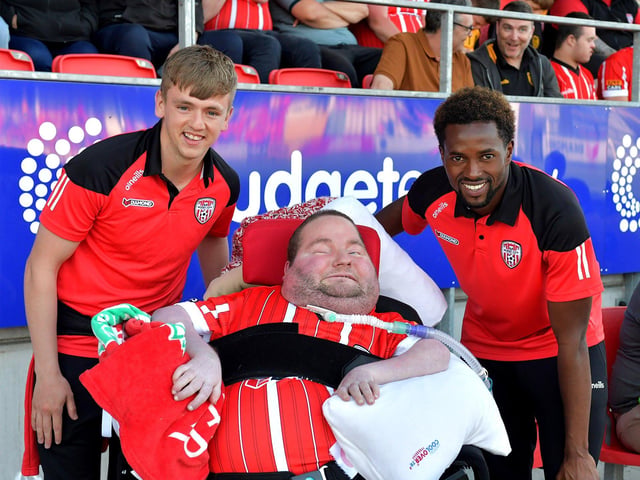 A Derry City fan pictured with players Ciaron Harkin and Sadou Diallo before the game against Shelbourne on Friday night.  Photo: George Sweeney. DER2321GS - 75