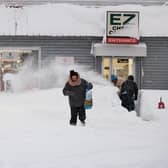 A resident leaves a local corner store in Buffalo, New York, on December 26, 2022, as many major grocery stores remained closed. - Emergency crews in New York were scrambling on December 26, 2022, to rescue marooned residents from what authorities called the "blizzard of the century," a relentless storm that has left dozens dead in the state and is causing US Christmas travel chaos. (Photo by Joed Viera / AFP) (Photo by JOED VIERA/AFP via Getty Images)