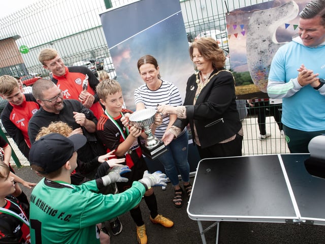 The Mayor presenting the Padraig Barton Cup to Phoenix captain Harrison Moore at the Bay Road on Tuesday afternoon. Included are members of the winning team, Derry City players Sam Todd and Ciaron Harkin, Colm Barton and Aine Barton, and on right, Colly Kelly, event organiser. (Photos: Jim McCafferty Photography)