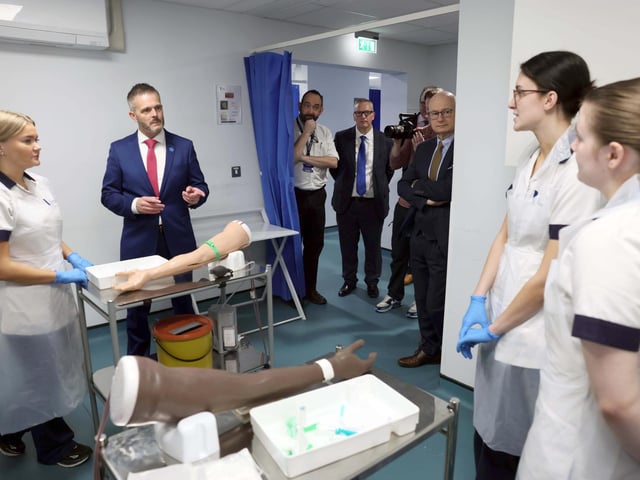 Health Minister Robbie Butler MLA talks to students within the Simulated Interprofessional Learning Centre designed to replicate clinical experiences helping students develop the confidence, competence and professional judgement required to deliver safe, compassionate care.