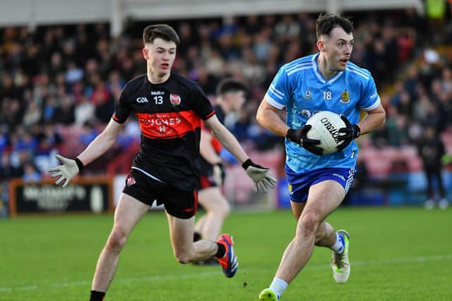 Ballinderry’s Eoin Devlin slips a tackle from Carrickcruppen’s Eoin Kane. Photo: George Sweeney