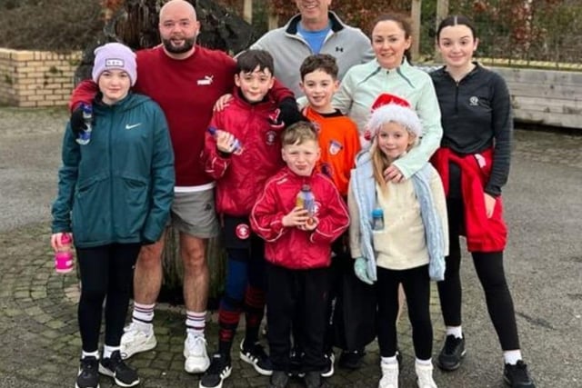 Kian Sweeney (centre) with his friends and family as he completed his final run as part of his fundraising efforts for SANDS NI