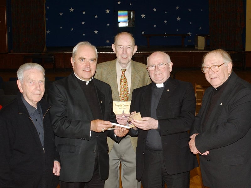 Most Rev. Dr. Seamus Hegarty receiving a copy of 'Derry City Cemetery 1853-2003' from Canon Bernard Canning at the official launch of his book in St. Eugene's Parish Hall. Included, from left, are Monsignor Matthew Kinsella, former VG, Paisley Diocese, Mr. David Bigger, former superintendent, City Cemetery, and Fr. James Hamilton, Corpus Christi, Texas, USA. (0606C101)