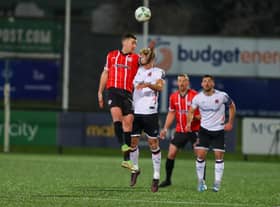 Derry skipper Patrick McEleney wins this header against Dundalk's Greg Sloggett. Photo: Kevin Moore