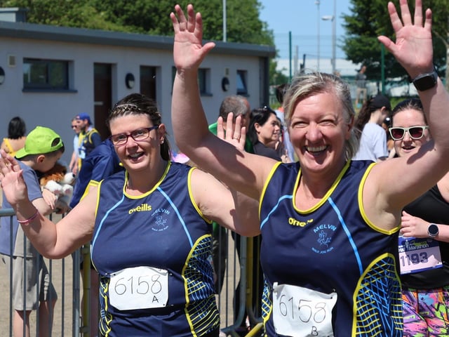 Members of the 'Carrie us over the line' relay team spot our cameraman on their way around the course.