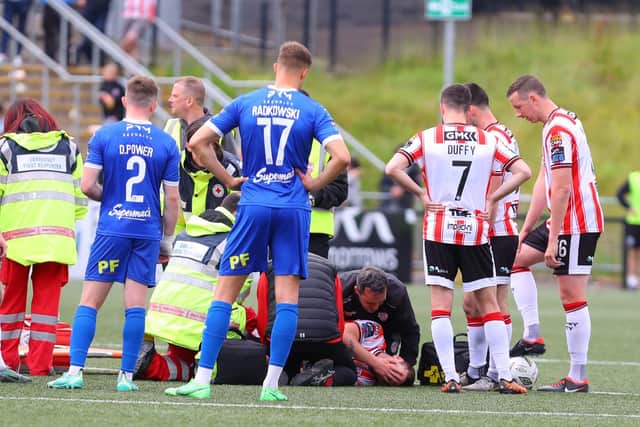Derry City skipper Patrick McEleney is attended to by the club physio and doctor on the pitch after sustaining what's feared to be a broken arm. Photograph by Kevin Moore.