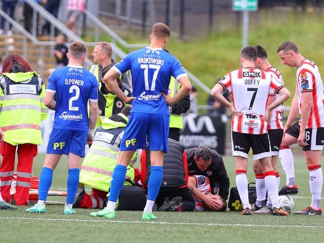 Derry City skipper Patrick McEleney is attended to by the club physio and doctor on the pitch after sustaining what's feared to be a broken arm. Photograph by Kevin Moore.