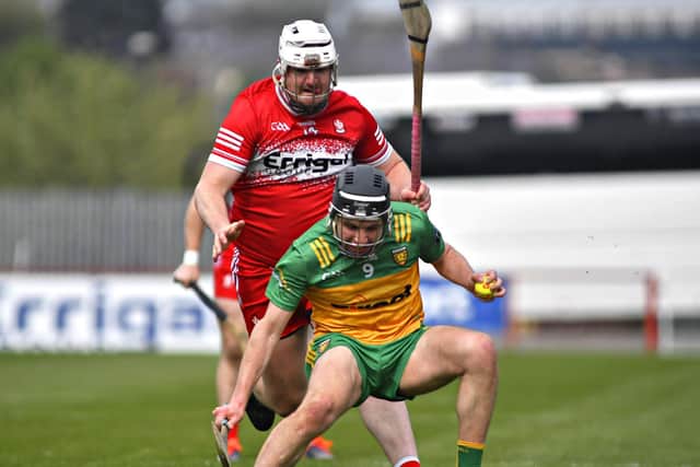Derry’s Christy McNaughton towers over Donegal’s Brian McIntyre.  Photo: George Sweeney