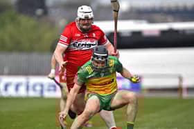 Derry’s Christy McNaughton towers over Donegal’s Brian McIntyre.  Photo: George Sweeney