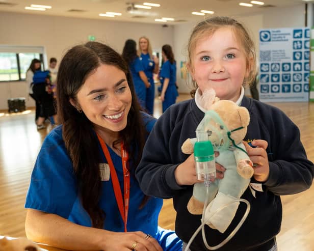 Student Jasmine Gallagher helps Sophie Wilson with her teddy’s oxygen supply