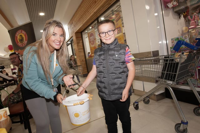 Molly Wilson, Cancer Fund for Children accepts a donation from young Finn Clarke at Lisnagelvin Shopping Centre's recent Annual Great Family Fun Day.
