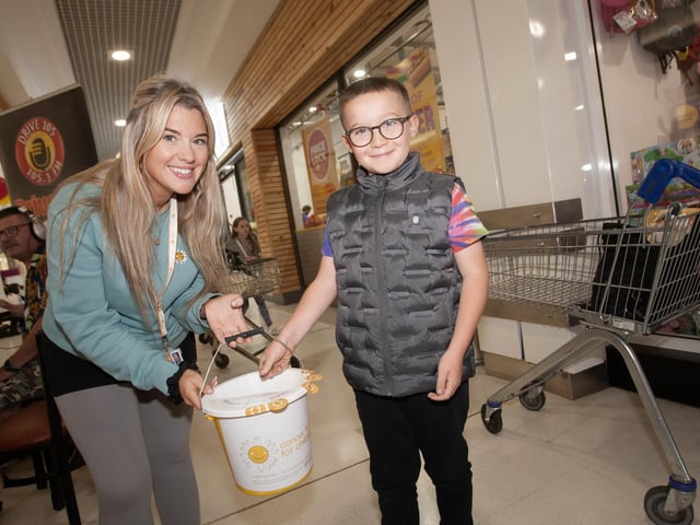 Molly Wilson, Cancer Fund for Children accepts a donation from young Finn Clarke at Lisnagelvin Shopping Centre's recent Annual Great Family Fun Day.