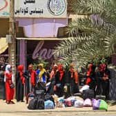 People wait for a bus to flee from southern Khartoum on April 18, 2023. (Photo by AFP) (Photo by -/AFP via Getty Images)