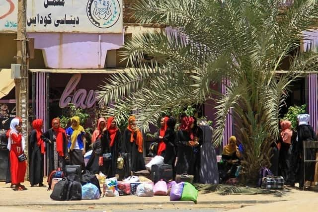 People wait for a bus to flee from southern Khartoum on April 18, 2023. (Photo by AFP) (Photo by -/AFP via Getty Images)