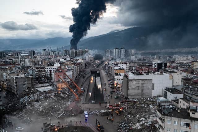 HATAY, TURKEY - FEBRUARY 07: Smoke billows from the Iskenderun Port as rescue workers work at the scene of a collapsed building on February 07, 2023 in Iskenderun, Turkey. A 7.8-magnitude earthquake hit near Gaziantep, Turkey, in the early hours of Monday, followed by another 7.5-magnitude tremor just after midday. The quakes caused widespread destruction in southern Turkey and northern Syria and were felt in nearby countries.  (Photo by Burak Kara/Getty Images)