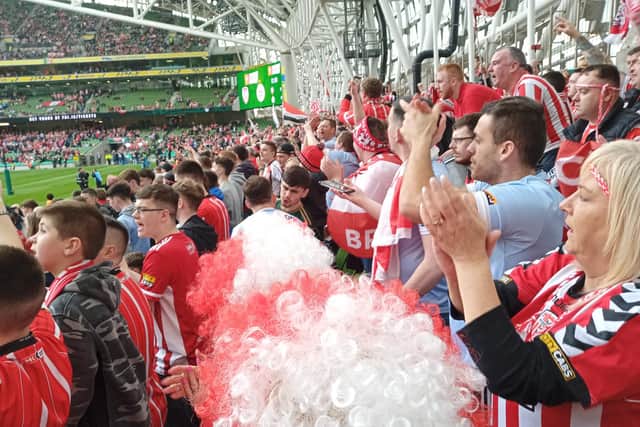 Derry fans applaud their team.