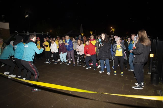Participants taking part in a gentle warm up before Saturday’s early morning walk/run.