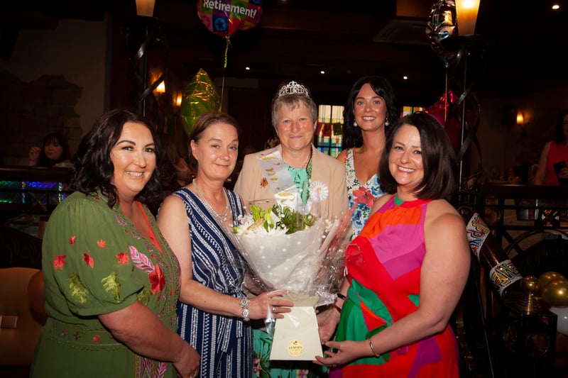 Ms. Linda Heaney receives a bouquet of flowers from colleagues at her retirement function in Da Vincis Hotel.