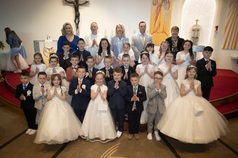 Pupils from Mrs. Fisher's class at St. Brigid's Primary School who received the Sacrament of First Holy Communion from Fr. Sean O'Donnell at St. Brigid's Church, Carnhill on Friday last. Included are Mrs. Eileen Fisher, Fr. Sean O'Donnell, Ms. Mary McCallion, Princpal, Mr. Kevin Fleming and Mrs. Iona Wiley, teaching assistants. (Photo: Jim McCafferty Photography)