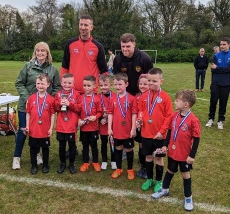 Derry City duo Shane McEleney and Cameron McJannet present Newel Academy with their Gerry Magee Cup runners up medals.