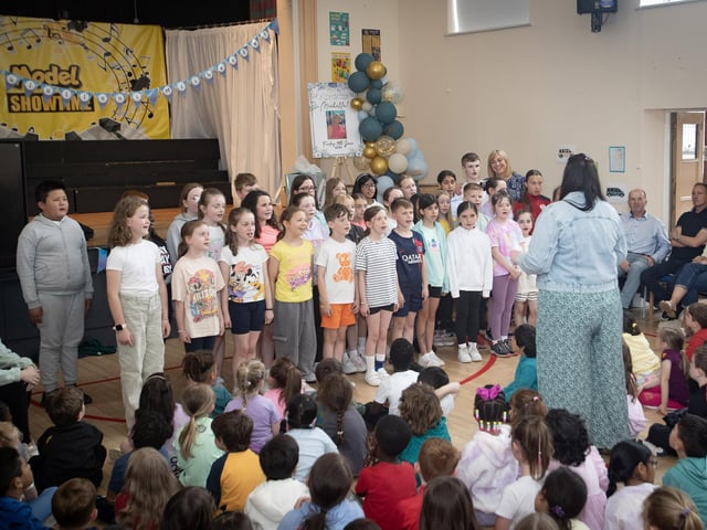 The School Choir at Model PS performs for a delighted Mrs. Ramsey on Friday.