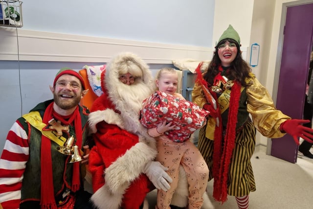 Saorlaith Barton, aged 5, from the Bogside pictured with Santa and his helpers at Altnagelvin Hospital.