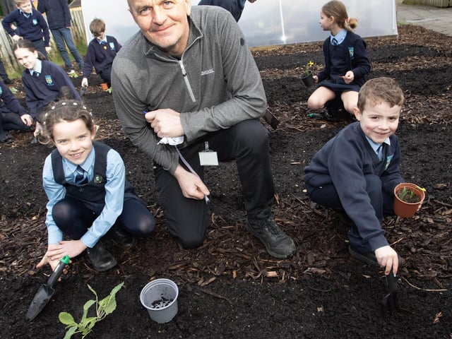 School caretaker Andy McDermott pictured advising pupils Cara and Liam in their new food growing garden project.