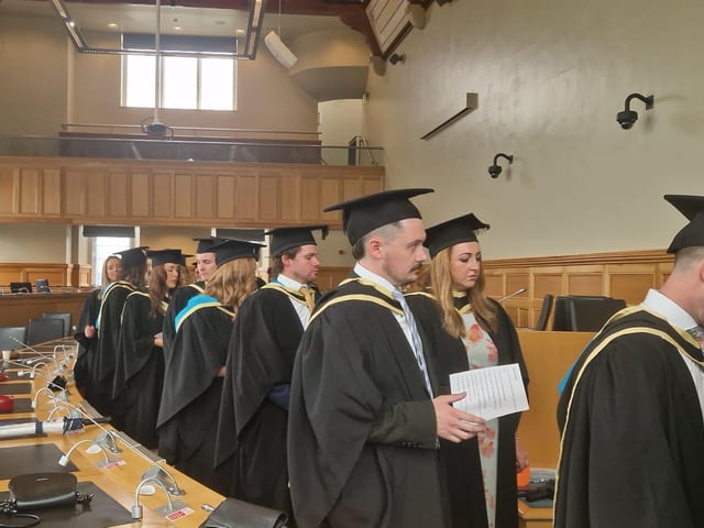 Graduates make their way from the Council chamber to the Main Hall in the Guildhall to complete their graduation.