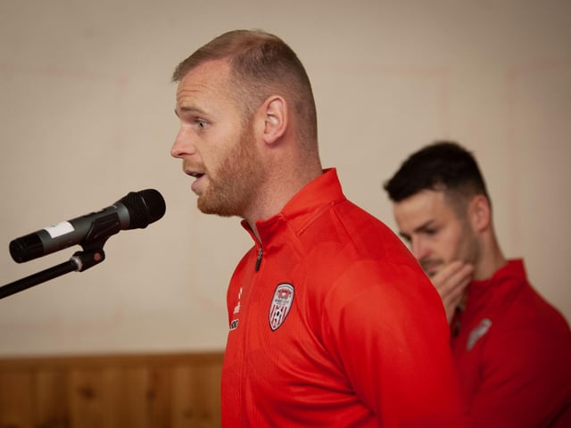 Derry City player Mark Connolly addresses the boys and girls of Hollybush PS during Tuesday's 'Red and White' Day.