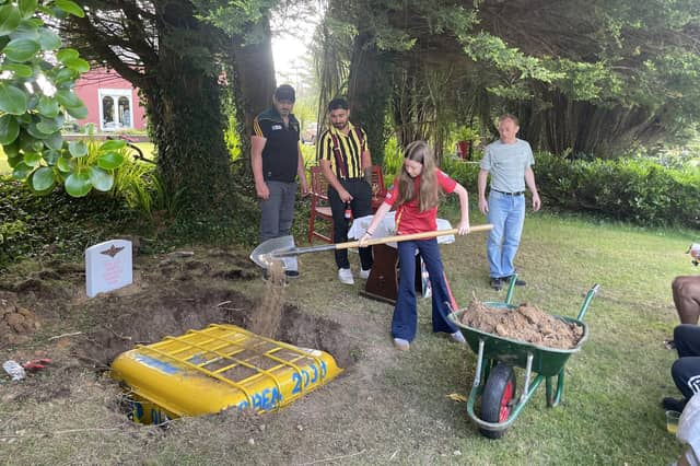 Abbi burying the time capsule and memory book.