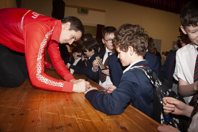 Derry City’s Ciaran Coll signing autographs for students at Oakgrove Integrated College.