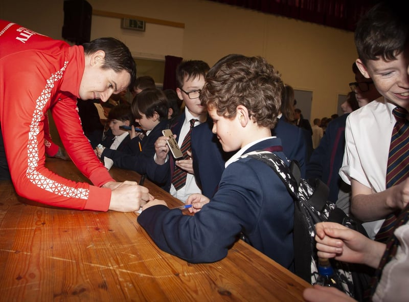 Derry City’s Ciaran Coll signing autographs for students at Oakgrove Integrated College.