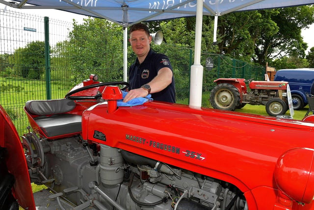 Gary Monagle, from the Inish Tractor Run, polishes a tractor that was raffled, in aid of the Donegal Hospice, at the Muff Vintage Show held in the Community Park on Sunday. Photo: George Sweeney.  DER2321GS – 04 
