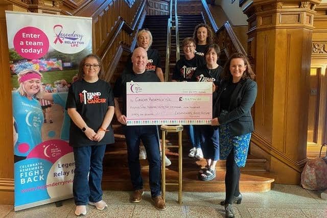 Legenderry Relay for Life committee members, including chairpersons,  Sean Hickey and Laura Moore,  presenting a cheque in the sum of £132,996 to Lisa Bailey, Cancer Research UK.